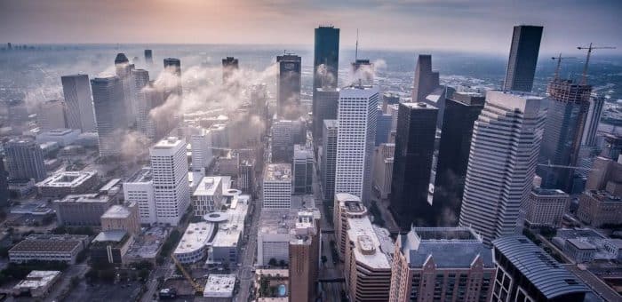a city from above with skyscrapers and clouds and mist around the buildings